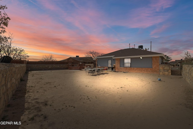 back of property featuring brick siding and a fenced backyard