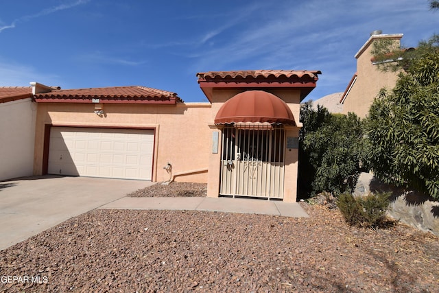 mediterranean / spanish house with an attached garage, concrete driveway, and stucco siding