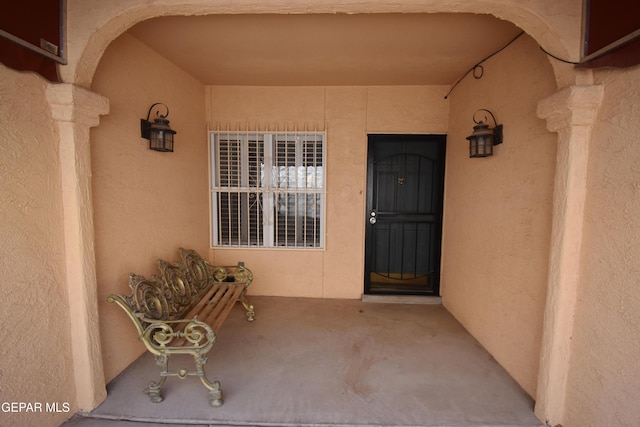 entrance to property featuring stucco siding