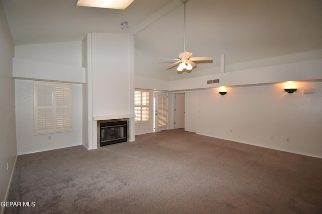 unfurnished living room featuring carpet floors, visible vents, a glass covered fireplace, ceiling fan, and high vaulted ceiling