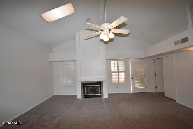 unfurnished living room with vaulted ceiling, carpet flooring, a glass covered fireplace, and visible vents