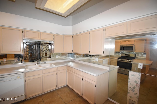 kitchen featuring light countertops, appliances with stainless steel finishes, a sink, and decorative backsplash