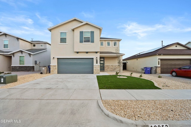 view of front of property featuring stone siding, a front yard, concrete driveway, and stucco siding