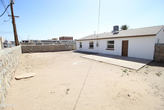 rear view of house featuring a patio, a fenced backyard, and central air condition unit