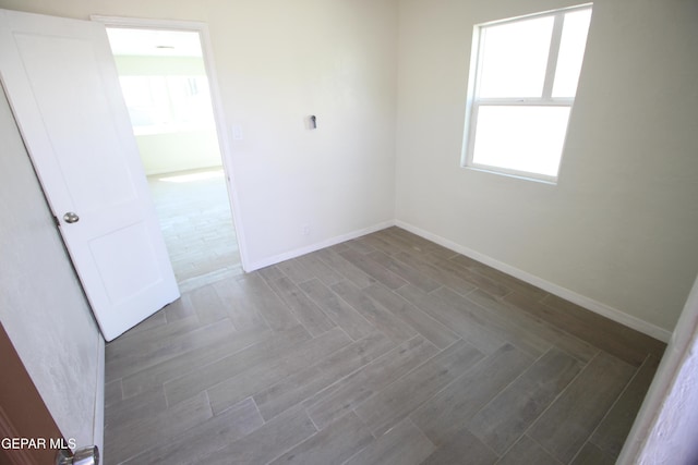 unfurnished room with baseboards and parquet flooring