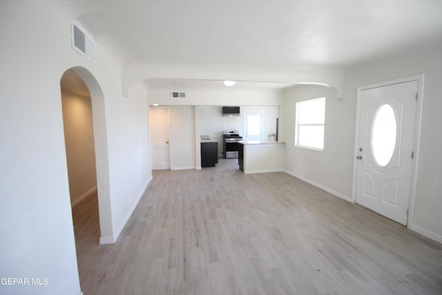 entryway with light wood finished floors, baseboards, and visible vents