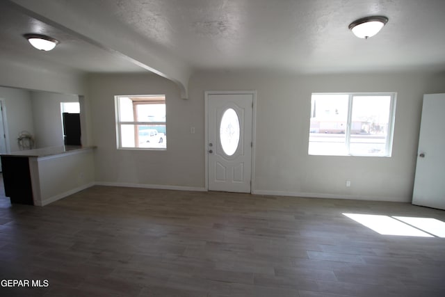 entrance foyer with a textured ceiling, wood finished floors, and baseboards