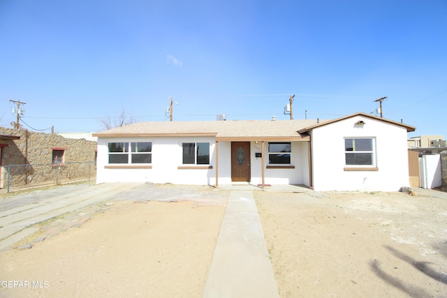 ranch-style home with fence and stucco siding