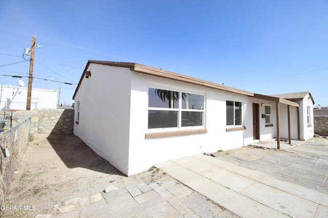 view of home's exterior featuring a patio area, fence, and stucco siding