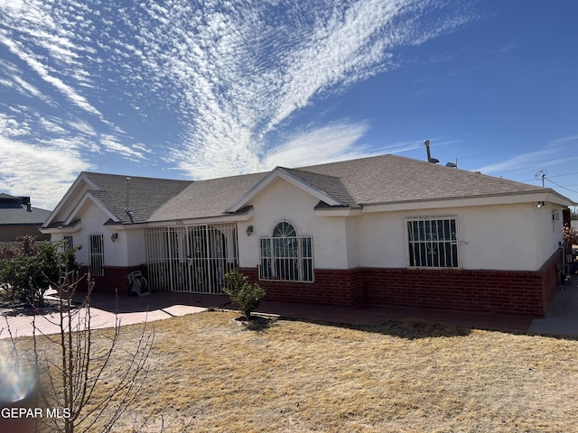 225 Peyton Rd, El Paso, TX 79928 - view of front of property featuring brick siding, stucco siding, a patio, and roof with shingles