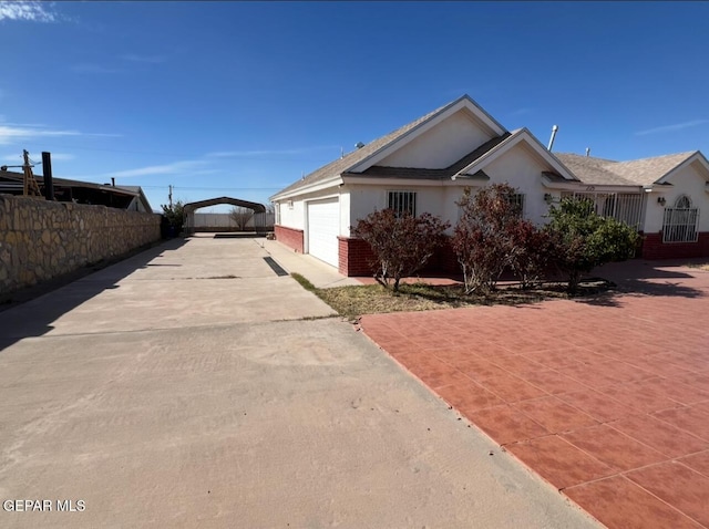 225 Peyton Rd, El Paso, TX 79928 - view of property exterior with concrete driveway, stucco siding, fence, an attached garage, and brick siding
