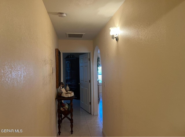 225 Peyton Rd, El Paso, TX 79928 - hallway featuring arched walkways, light tile patterned floors, and a textured wall
