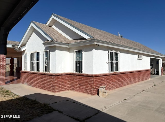 225 Peyton Rd, El Paso, TX 79928 - view of property exterior featuring brick siding, stucco siding, a patio, and a shingled roof