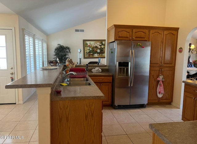 225 Peyton Rd, El Paso, TX 79928 - kitchen featuring stainless steel fridge, a sink, light tile patterned floors, vaulted ceiling, and arched walkways