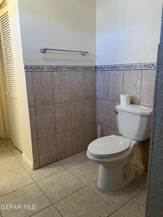 225 Peyton Rd, El Paso, TX 79928 - half bath featuring tile walls, tile patterned floors, toilet, and wainscoting