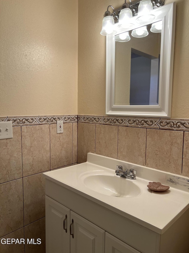 225 Peyton Rd, El Paso, TX 79928 - bathroom featuring tile walls, vanity, a textured wall, and wainscoting