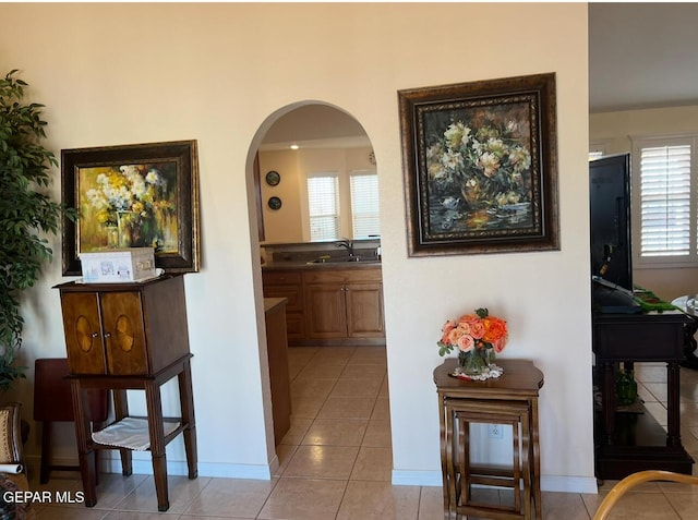 225 Peyton Rd, El Paso, TX 79928 - hallway featuring a sink, light tile patterned floors, arched walkways, and baseboards