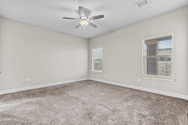 unfurnished room featuring carpet, visible vents, ceiling fan, and baseboards