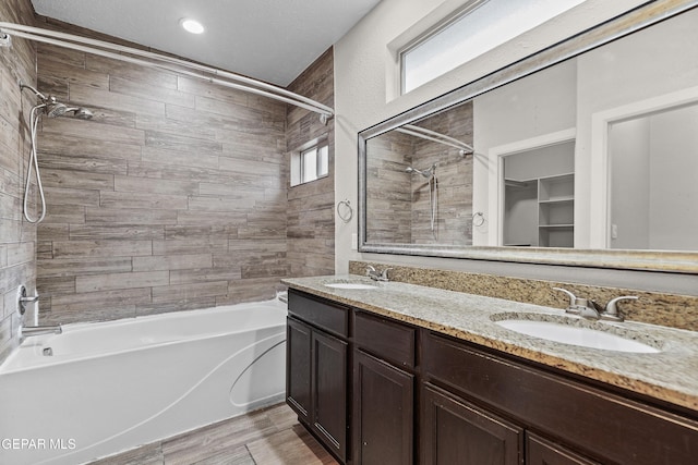 bathroom with double vanity, a sink, and shower / bathtub combination