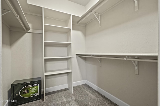 spacious closet featuring dark carpet