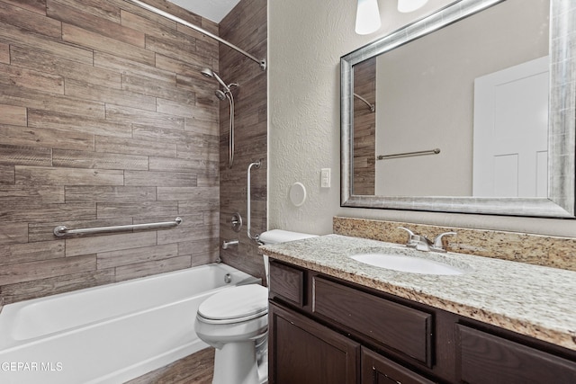 full bathroom with a textured wall, toilet, wood finished floors, vanity, and washtub / shower combination