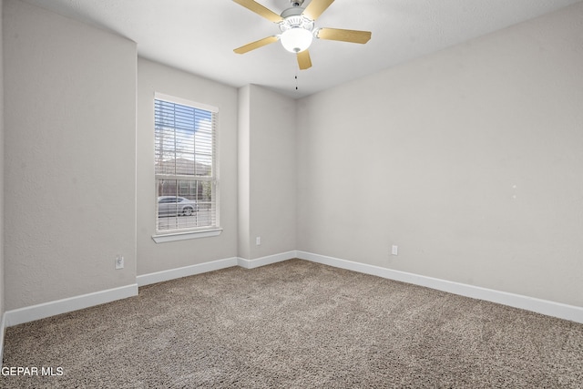 carpeted spare room with baseboards and a ceiling fan