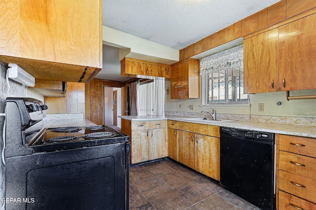 kitchen featuring a textured ceiling, black appliances, light countertops, and a sink