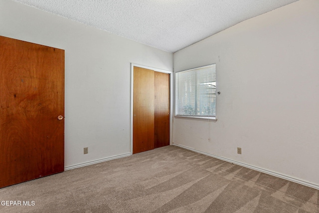 unfurnished bedroom featuring a closet, carpet, and a textured ceiling