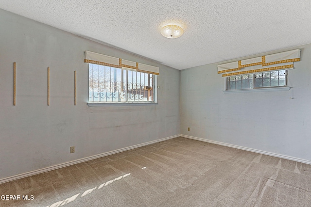 unfurnished room featuring baseboards, carpet, and a textured ceiling