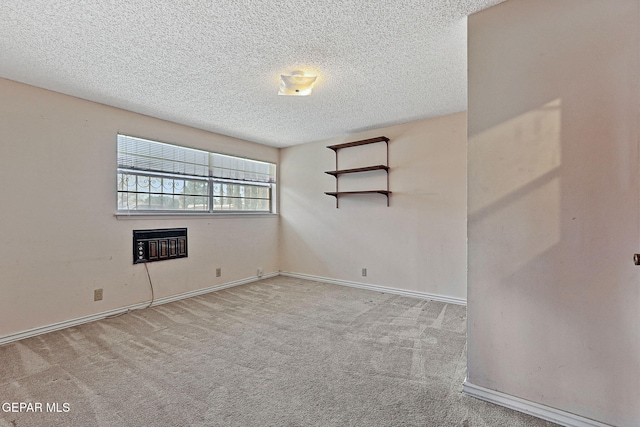 carpeted empty room with a glass covered fireplace, a textured ceiling, and baseboards