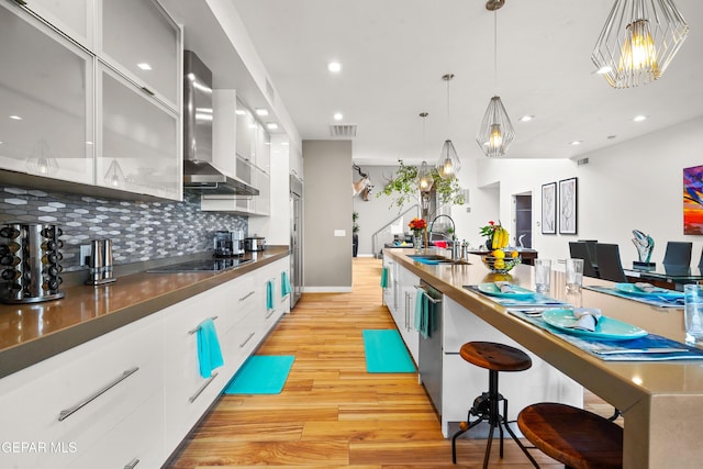 kitchen featuring black electric stovetop, modern cabinets, a sink, and visible vents