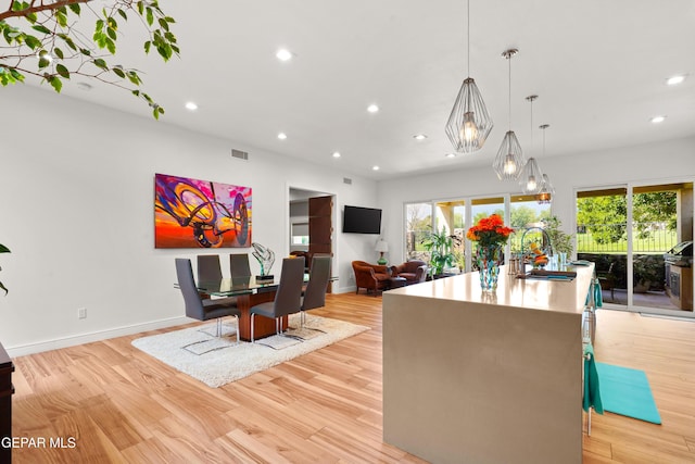 dining area featuring a healthy amount of sunlight, light wood finished floors, and recessed lighting