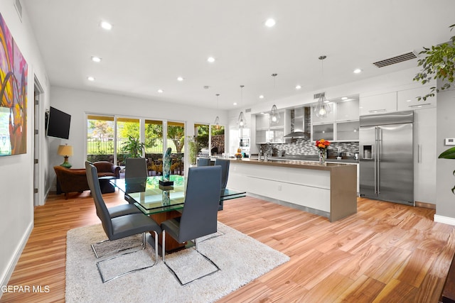 dining space featuring light wood-style floors, recessed lighting, visible vents, and baseboards