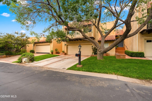 view of front of house with a garage, a front yard, a tiled roof, and stucco siding