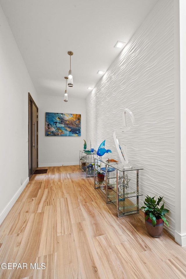 corridor featuring baseboards and wood finished floors