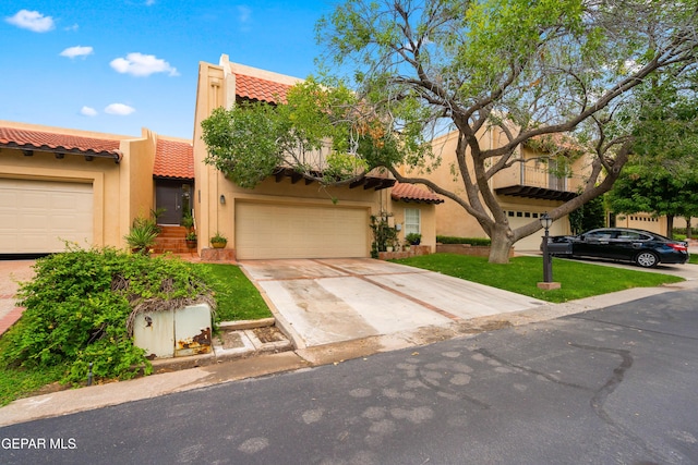 view of front facade with a tile roof, concrete driveway, and stucco siding