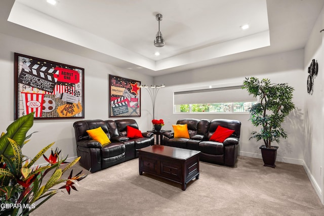 living area featuring a tray ceiling, light carpet, baseboards, and recessed lighting