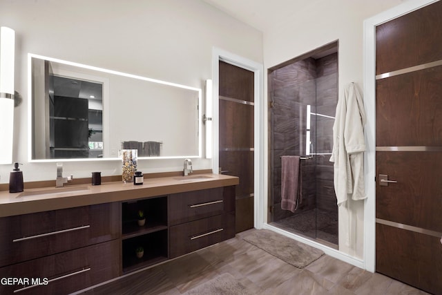 full bathroom featuring double vanity, a stall shower, and a sink