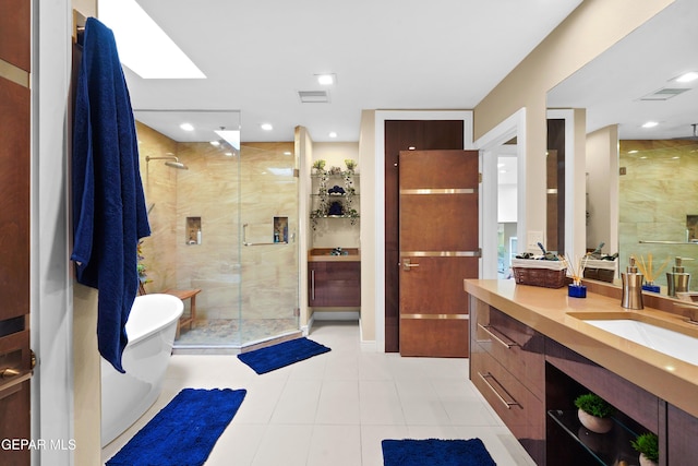 bathroom featuring tile patterned flooring, visible vents, vanity, a freestanding bath, and a shower stall