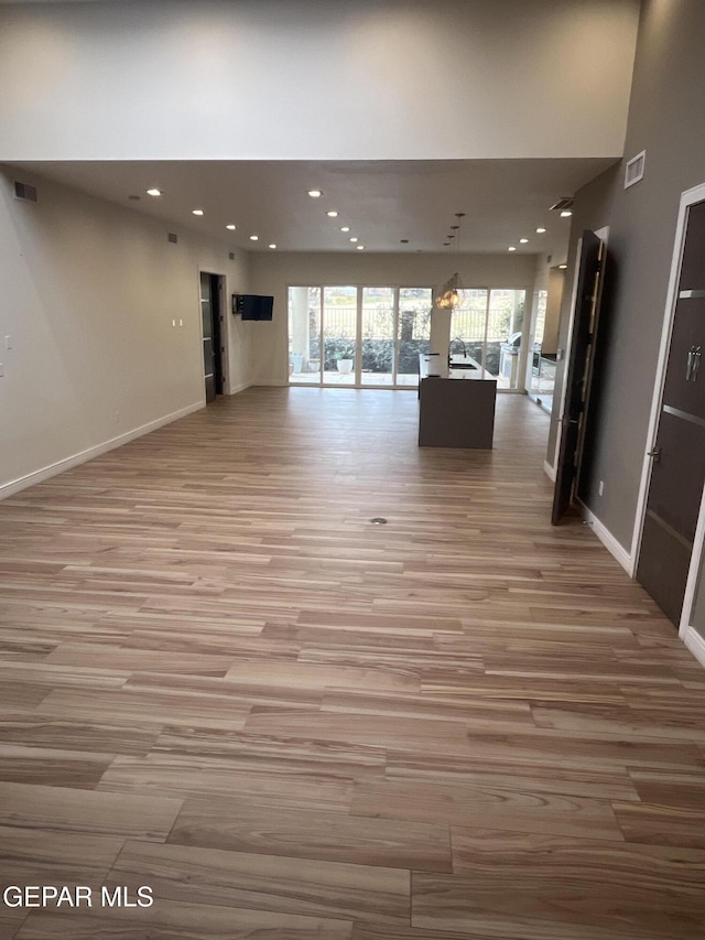 unfurnished living room with baseboards, visible vents, and a healthy amount of sunlight