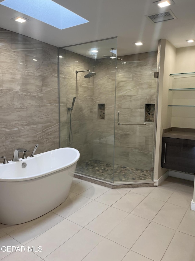 full bath featuring tile walls, visible vents, a freestanding bath, a stall shower, and tile patterned floors