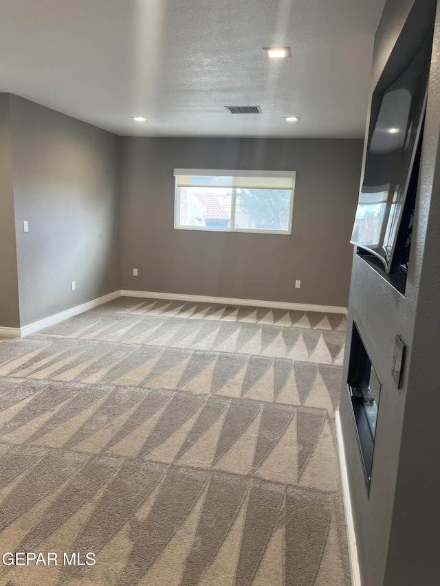 carpeted empty room with recessed lighting, visible vents, and baseboards