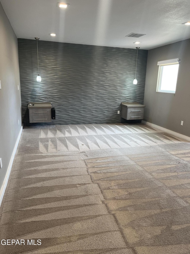 unfurnished room featuring carpet, visible vents, and baseboards