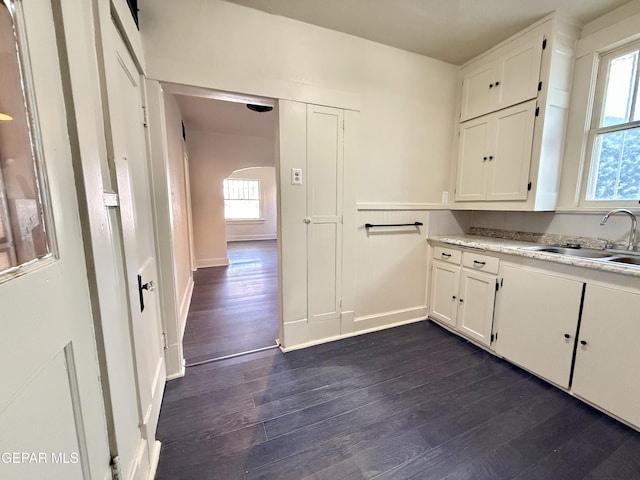 kitchen with white cabinets, dark wood finished floors, and a sink