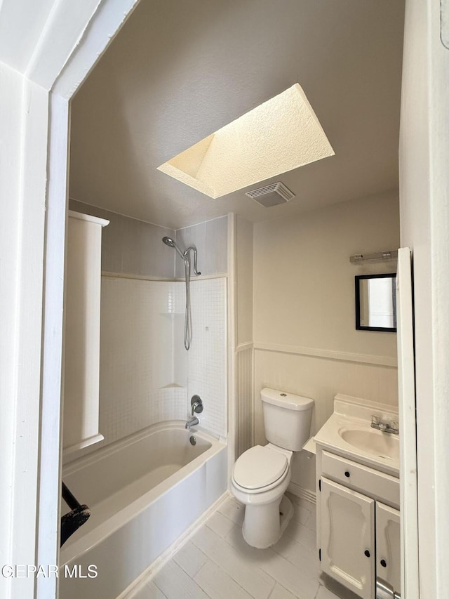 bathroom with shower / bath combination, a skylight, visible vents, toilet, and vanity