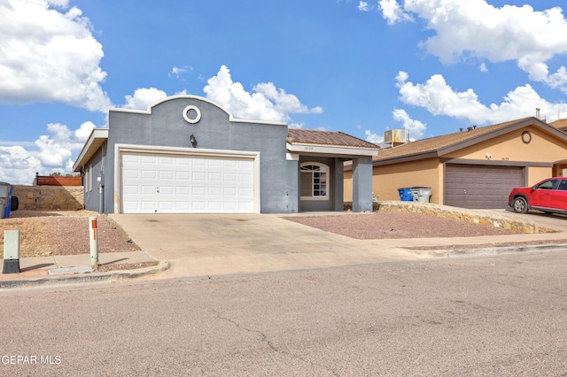 view of front of house with cooling unit, driveway, and stucco siding