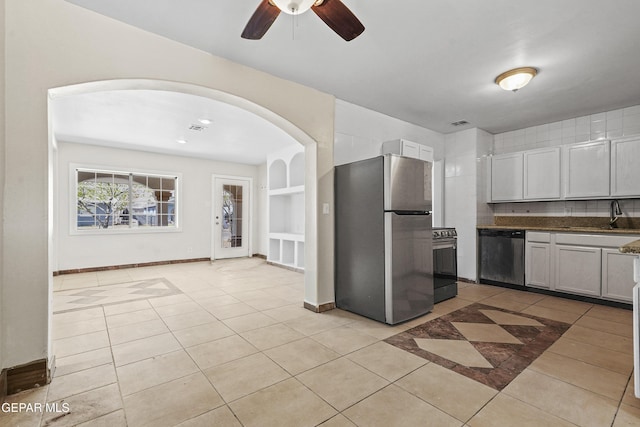 kitchen featuring light tile patterned flooring, built in shelves, stainless steel appliances, and a sink