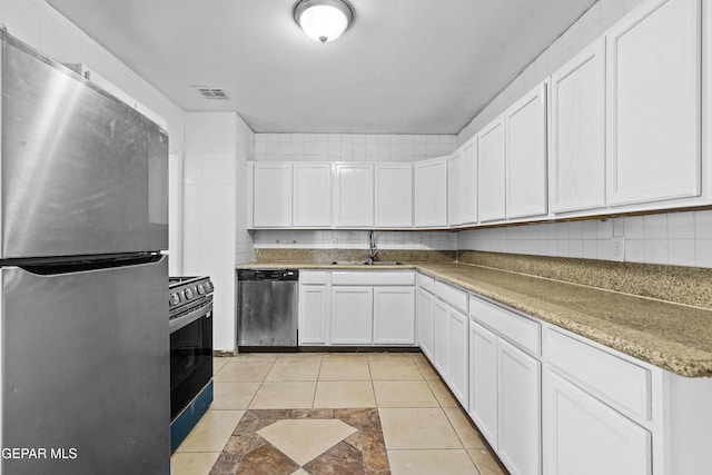 kitchen featuring visible vents, a sink, decorative backsplash, appliances with stainless steel finishes, and white cabinetry