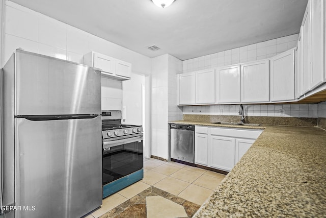 kitchen with visible vents, stainless steel appliances, decorative backsplash, and a sink