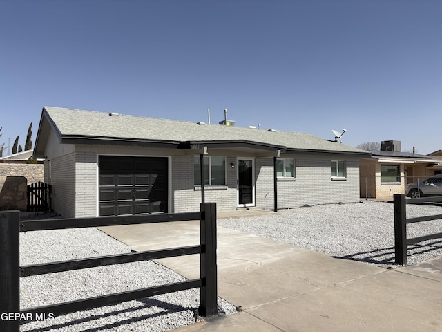 single story home with a garage, brick siding, fence, and central AC unit